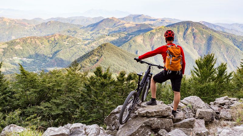 man staying fit while traveling by mountain biking